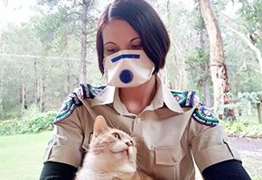 Woman wearing a mask while holding a cat